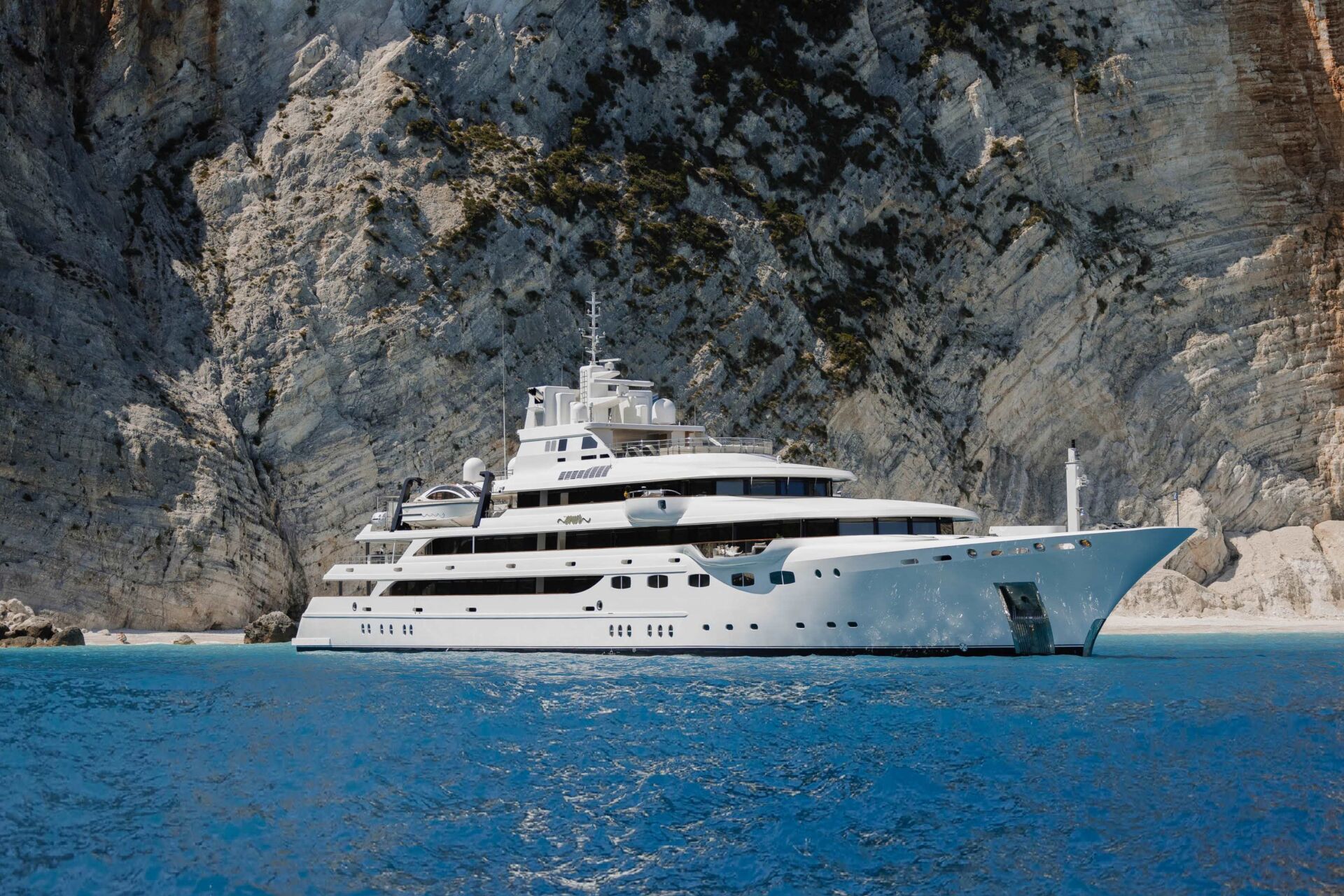 A superyacht anchored in a turquoise cove